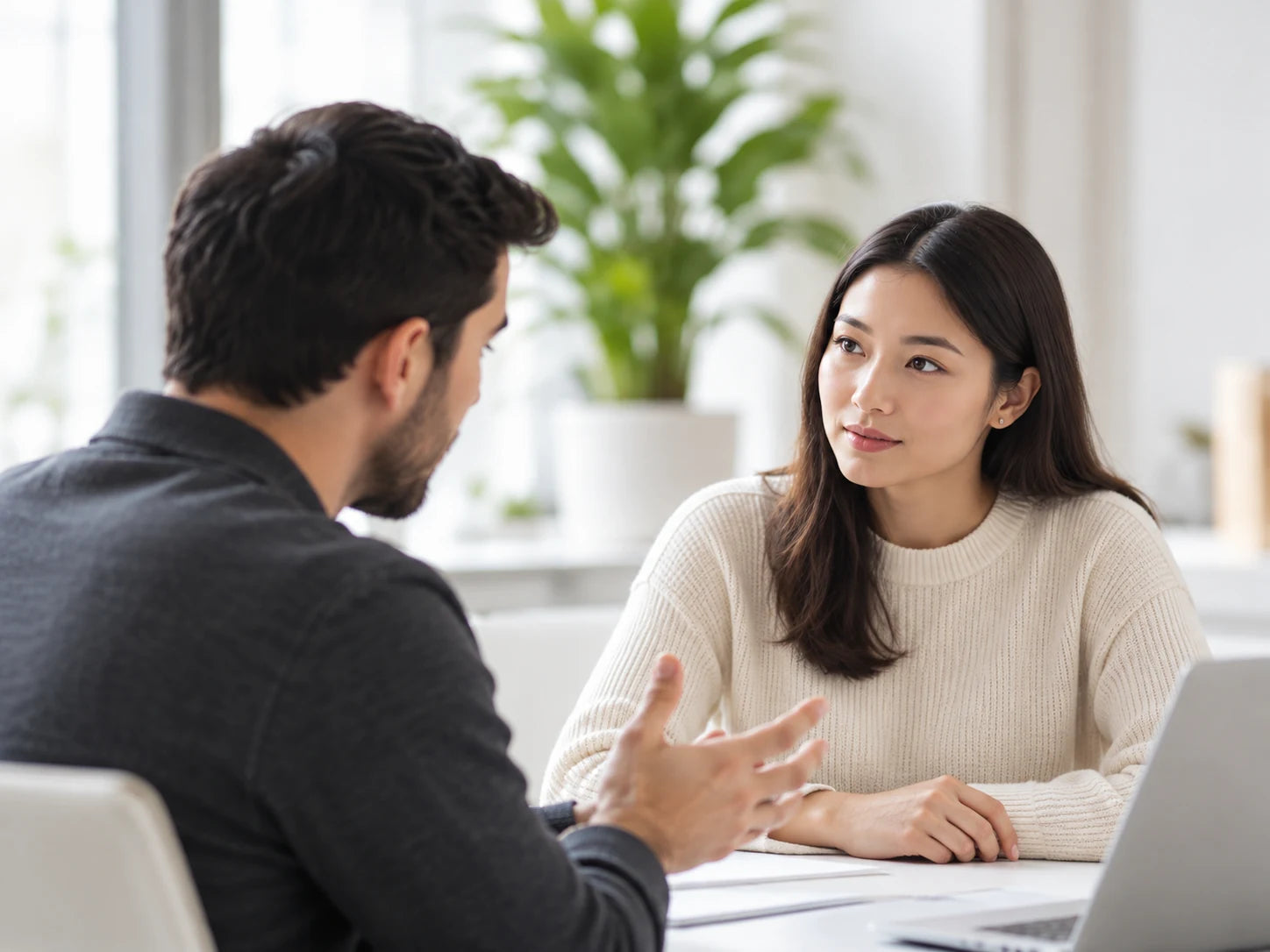 Two people discussing business in a bright, minimal workspace